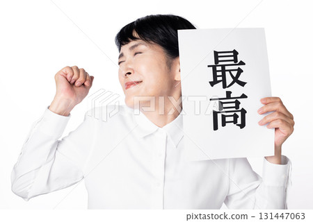 一位老婦人高興地揮舞著拳頭以示感激，手裡拿著一張寫著「最好」的紙 131447063