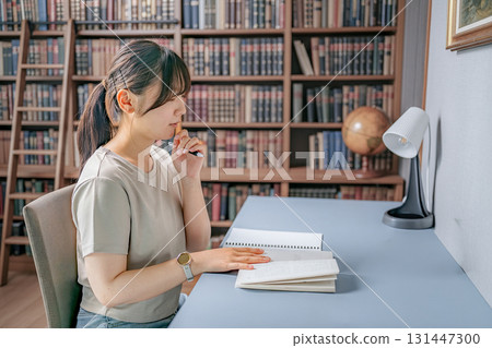 A woman reading a book in the study A woman reading a book in the study 131447300