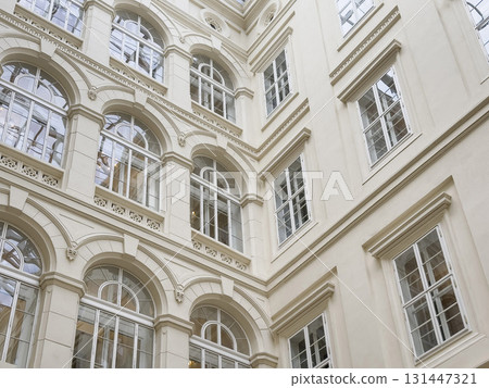 Elegant Neoclassical Building Facade background with Arched Windows and Ornate Architectural Details Elegant Neoclassical Building Facade background with Arched Windows and Ornate Architectural Details 131447321