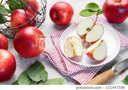 Fresh red apples in basket and sliced on plate 131447386