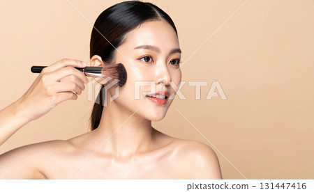 一位日本女性用化妝刷輕敲臉頰的側影 一位日本女性用化妝刷輕敲臉頰的側影 131447416