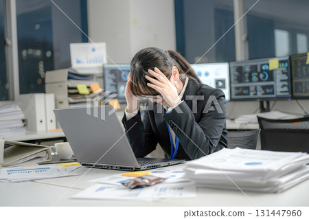 Businesswoman worried about her cluttered desk Businesswoman worried about her cluttered desk 131447960