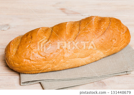 Assortment of freshly baked bread with napkin on rustic table top view. Healthy unleavened bread. French bread Assortment of freshly baked bread with napkin on rustic table top view. Healthy unleavened bread. French bread 131448679