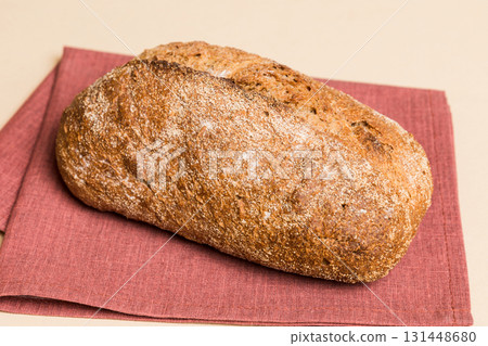 Assortment of freshly baked bread with napkin on rustic table top view. Healthy unleavened bread. French bread Assortment of freshly baked bread with napkin on rustic table top view. Healthy unleavened bread. French bread 131448680