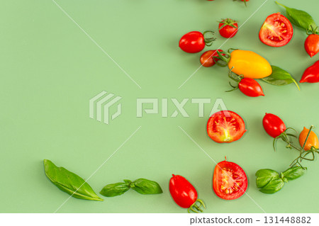 Cherry tomatoes and basil leaves on soft green background Cherry tomatoes and basil leaves on soft green background 131448882