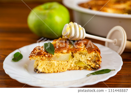 Airy pastries with apple slices and a mint sprig for serving 131448887