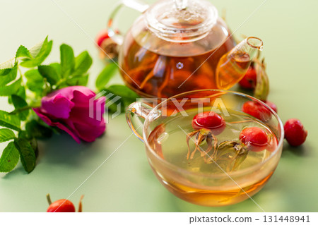 hot natural tea and rose hips on a green background hot natural tea and rose hips on a green background 131448941