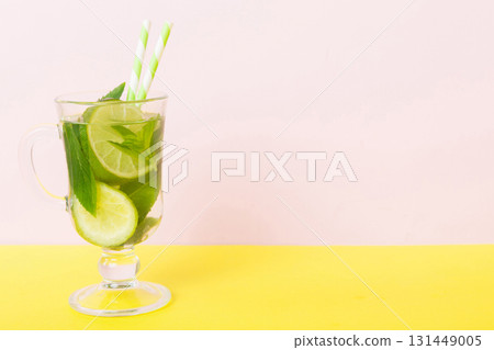 Mojito summer refreshing cocktail with ice and mint. mojito cocktail with lime, lemon and mint in a tall glass with a stick 131449005