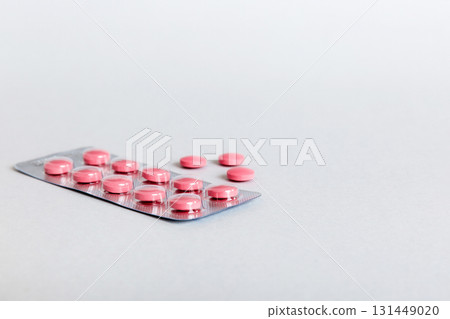 Blister package with Vitamin on color background. Medicine pills on a light background. Medicines and prescription pills flat lay background. pink medical tablets in blister Blister package with Vitamin on color background. Medicine pills on a light background. Medicines and prescription pills flat lay background. pink medical tablets in blister 131449020