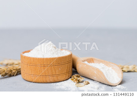 Flat lay of Wheat flour in wooden bowl with wheat spikelets on colored background. world wheat crisis 131449110
