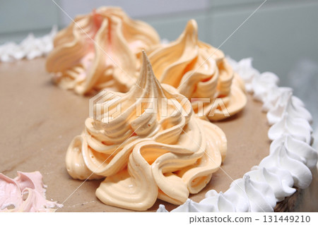 Confectioner woman is pouring cream on sponge cake using pastry bag, closeup view. Pastry chef is cooking homemade cake. cooking, baking and cooking, home cooking Confectioner woman is pouring cream on sponge cake using pastry bag, closeup view. Pastry chef is cooking homemade cake. cooking, baking and cooking, home cooking 131449210