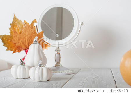 Autumn Still Life with White Pumpkins, Mirror, and Fall Leaves. Cozy Seasonal Home Decor 131449265