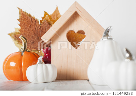 Minimal Wooden House with Heart and Pumpkins. Cozy Autumn Decor Minimal Wooden House with Heart and Pumpkins. Cozy Autumn Decor 131449288
