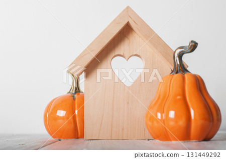 Minimal Wooden House with Heart and Pumpkins. Cozy Autumn Decor Minimal Wooden House with Heart and Pumpkins. Cozy Autumn Decor 131449292