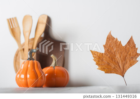 Autumn Kitchen Decor with Wooden Utensils and Ceramic Pumpkins 131449316