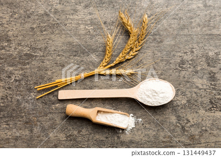 Flat lay of Wheat flour in wooden bowl with wheat spikelets on colored background. world wheat crisis 131449437