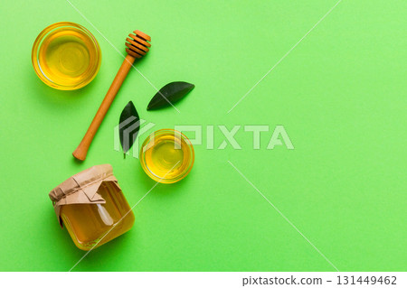 Honey jar with wooden honey dipper on white background top view with copy space. Delicious honey bottle Honey jar with wooden honey dipper on white background top view with copy space. Delicious honey bottle 131449462