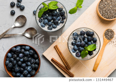 Healthy breakfast or morning with chia seeds vanilla pudding and blueberry berries on table background, vegetarian food, diet and health concept. Chia pudding with coconut milk and blueberry 131449467