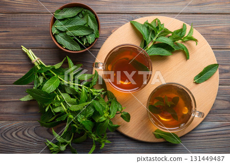 Cup of mint tea on table background. Green tea with fresh mint top view with copy space 131449487