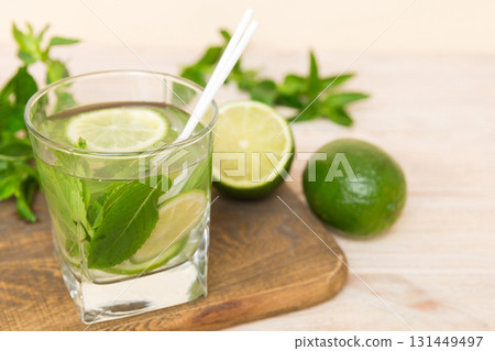 Mojito cocktail. Refreshing mojito cocktail with lime, lemon and mint in a tall glass with a stick Mojito cocktail. Refreshing mojito cocktail with lime, lemon and mint in a tall glass with a stick 131449497