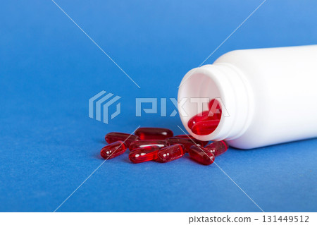 Red pills spilled around a pill bottle. Medicines and prescription pills flat lay background. Red medical capsules Red pills spilled around a pill bottle. Medicines and prescription pills flat lay background. Red medical capsules 131449512
