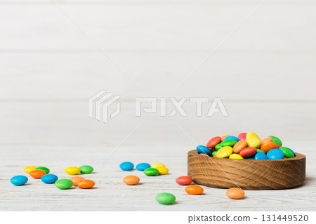 Multicolored candies in a bowl on a colored background. birthday and holiday concept. Top view with copy space 131449520