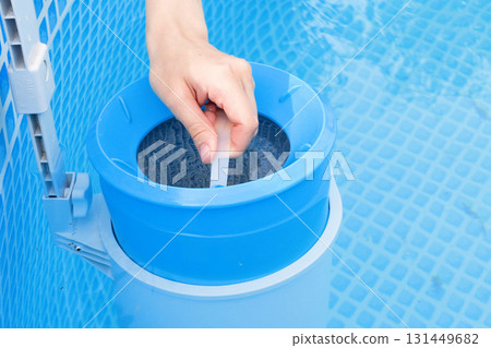 girl cleans skimmer for the frame pool. Contaminated pool cleaning concept 131449682