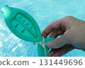 a man hand checks the temperature with a thermometer on a sunny day 131449696