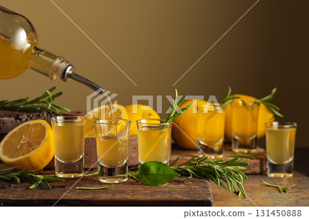 Italian liqueur Limoncello with fresh lemons and rosemary branches. Italian liqueur Limoncello with fresh lemons and rosemary branches. 131450888