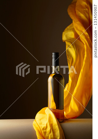 Bottle of white wine and flutters of yellow cloth. Bottle of white wine and flutters of yellow cloth. 131450907