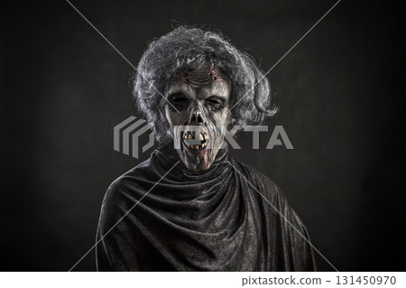 Scary zombie with gray hair over dark background Scary zombie with gray hair over dark background 131450970