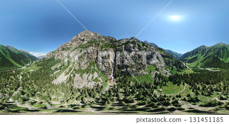 Waterfall cascading down rocky mountainside in sunny valley in Burkhan Bulak National Park, Kazakhstan 131451185