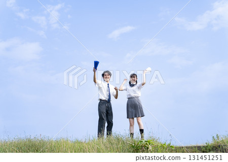 High school students cheering with a blue sky in the background High school students cheering with a blue sky in the background 131451251