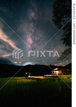 A hut in the middle of a rice field and the belly of a milky way, stars and a night sky with clouds A hut in the middle of a rice field and the belly of a milky way, stars and a night sky with clouds 131452434
