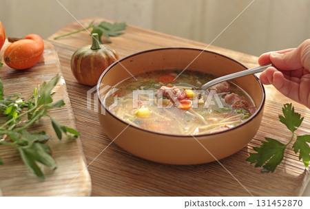Traditional Italian minestrone soup with vegetables, sausage, and pasta, served in clay bowl on wooden board. Food and healthy lifestyle. Mediterranean cuisine. Traditional Italian minestrone soup with vegetables, sausage, and pasta, served in clay bowl on wooden board. Food and healthy lifestyle. Mediterranean cuisine. 131452870