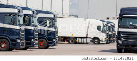 Modern blue cargo truck delivery van parked logistics warehouse center complex building exterior bay. Semi-trailer lorry unload goods distribution blue sky. Cargo storage facility industry building 131452921