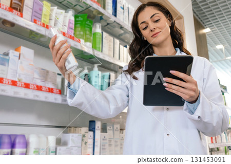Woman in uniform holding clipboard checking medicine supplies Woman in uniform holding clipboard checking medicine supplies 131453091