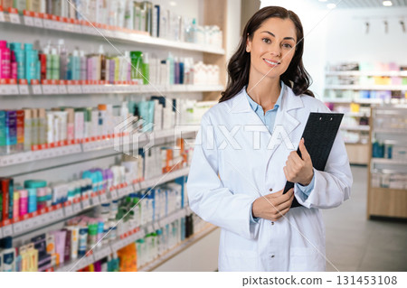 Pharmacist woman smiling with clipboard in hand in pharmacy 131453108