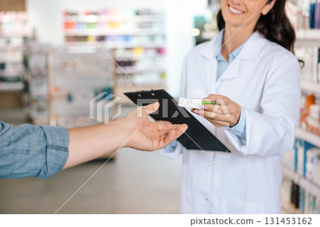 Unrecognizable woman pharmacist giving pills to client 131453162