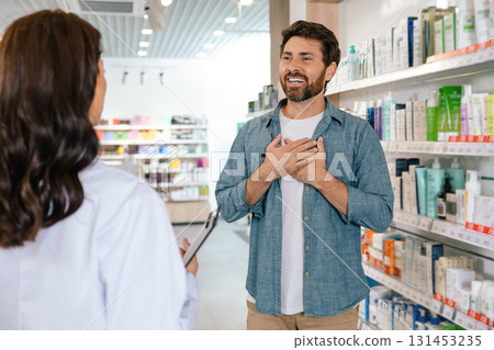 Pharmacist and male patient discussing healthcare products in retail pharmacy Pharmacist and male patient discussing healthcare products in retail pharmacy 131453235