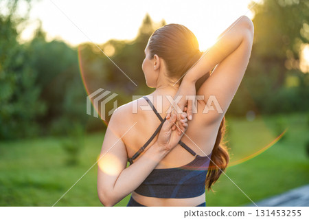 Waist up of a woman stretching her arms while doing yoga Waist up of a woman stretching her arms while doing yoga 131453255