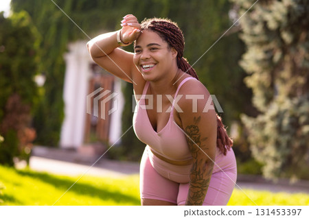 Young woman in pink sportswear looking tired after workout Young woman in pink sportswear looking tired after workout 131453397
