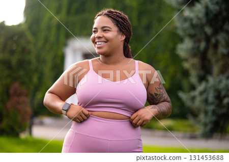 Smiling young woman in pink sportswear looking confident 131453688