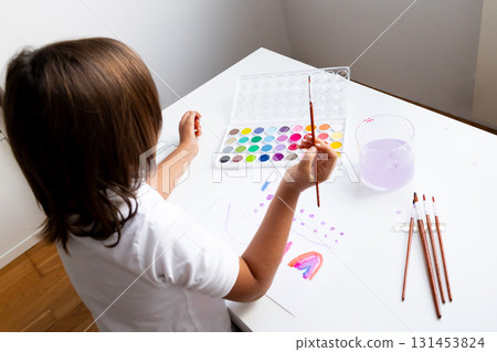 Young caucasian girl painting with watercolors at home art session 131453824