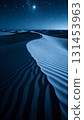 Wind patterns in the indigo desert dunes under a starry sky 131453963