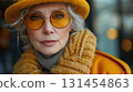 Old fashionable woman, street photo. Lady with grey hair wearing yellow sunglasses and mustard jacket, portrait, outdoors 131454863