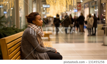 A cozy scene of a shopper sitting on a bench in a mall during Black Friday, relaxing while people rush around shopping. Consumerism, sales, black friday. Online shopping. 131455256