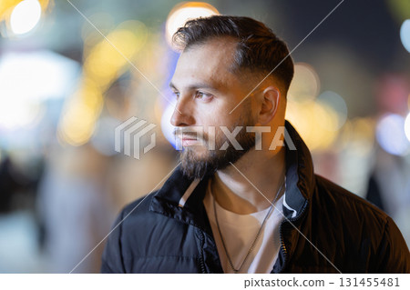 Young man looking away on bokeh city night 131455481
