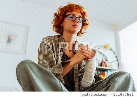 Teen girl with broken arm, wearing glasses, red hair, in bedroom 131455651