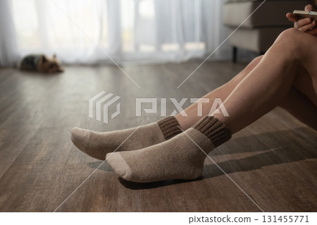 Enjoying Comfort on Underfloor Heating With Cozy Socks Indoors Enjoying Comfort on Underfloor Heating With Cozy Socks Indoors 131455771